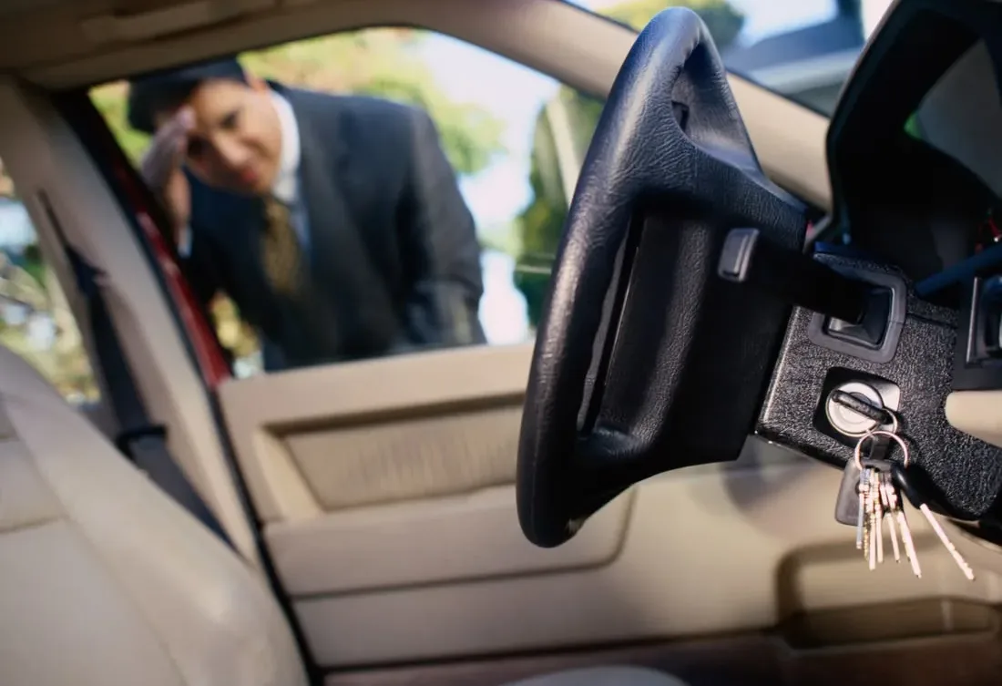 A locksmith assisting at an open vehicle door.